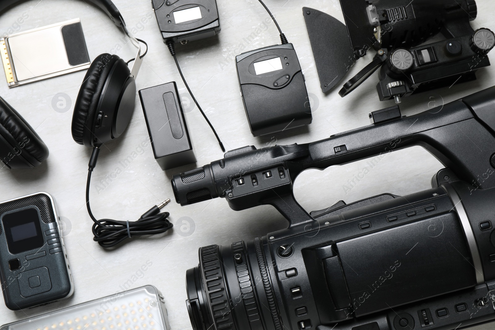 Photo of Flat lay composition with camera and video production equipment on light grey background