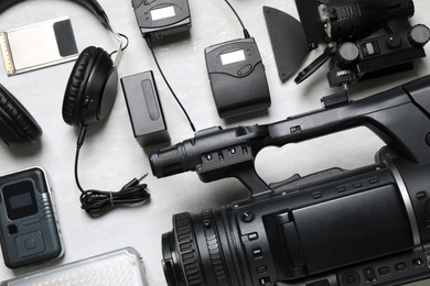 Flat lay composition with camera and video production equipment on light grey background