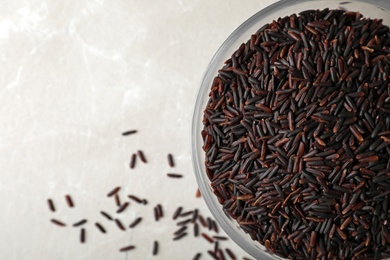 Photo of Bowl with brown rice on table, top view. Space for text