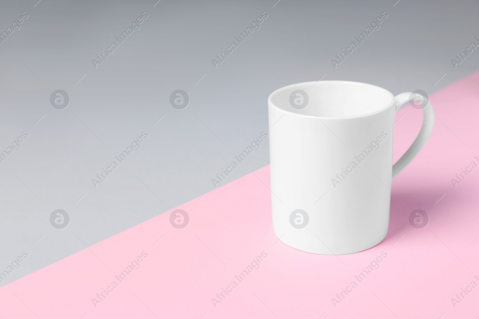 One white ceramic mug on color background, space for text Photo of One white ceramic mug on color background, space for text