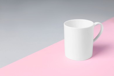 Photo of One white ceramic mug on color background, space for text