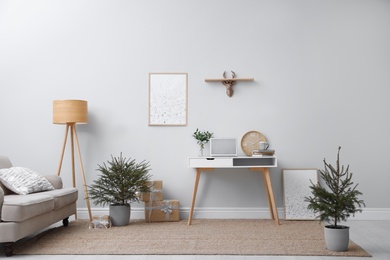 Photo of Stylish room interior with potted fir trees decorated for Christmas