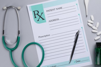 Photo of Medical prescription form, stethoscope, pills and thermometer on light grey background, flat lay