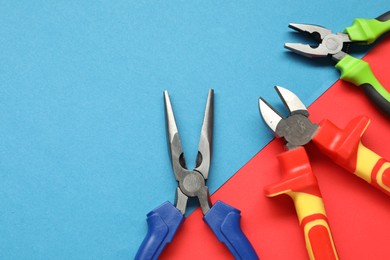 Photo of Different pliers on color background, flat lay. Space for text