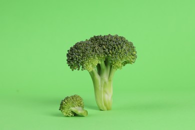 Fresh raw broccoli on light green background