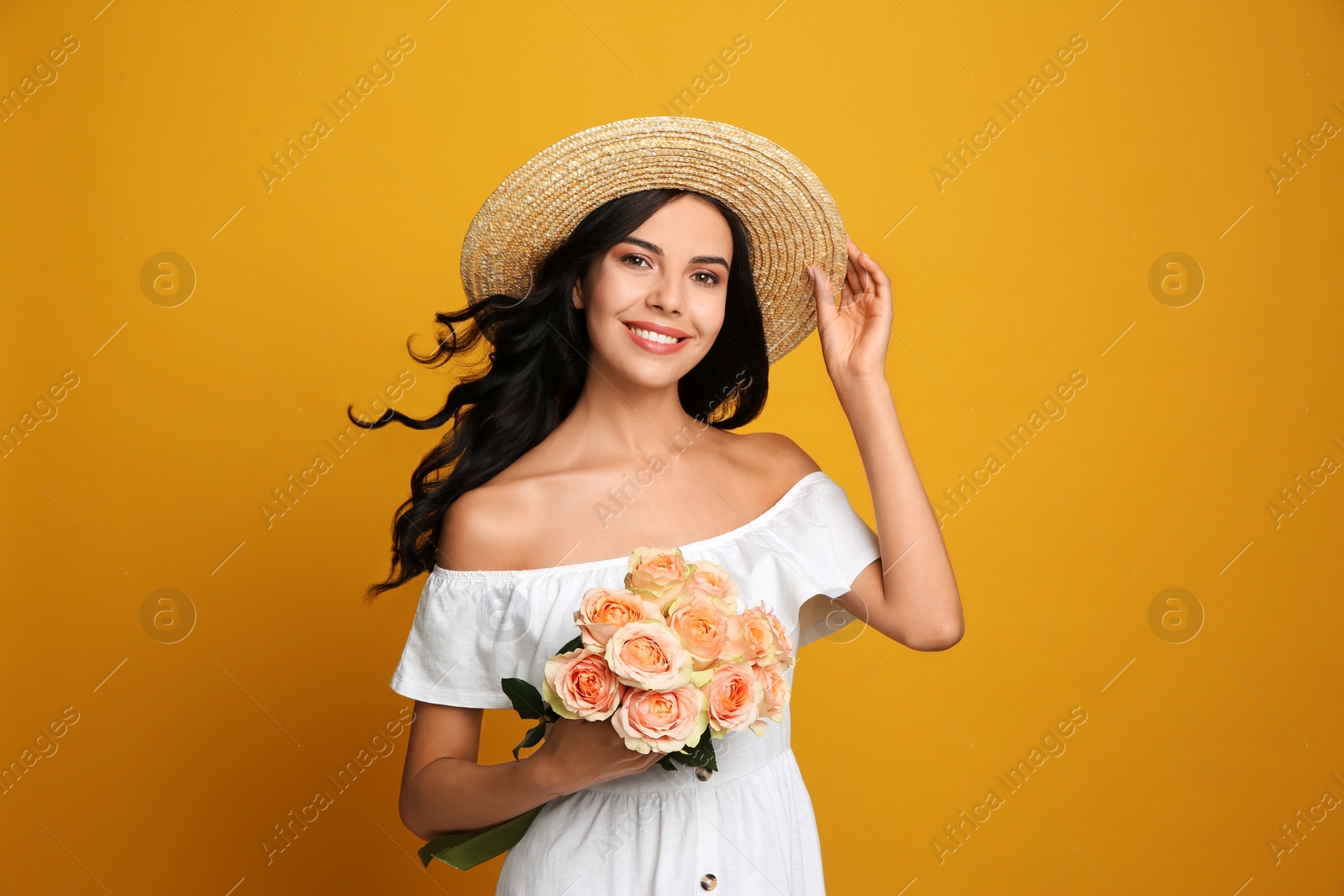 Photo of Portrait of smiling woman with beautiful bouquet on orange background