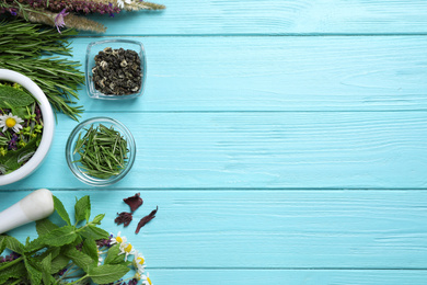 Photo of Flat lay composition with healing herbs on light blue wooden table. Space for text
