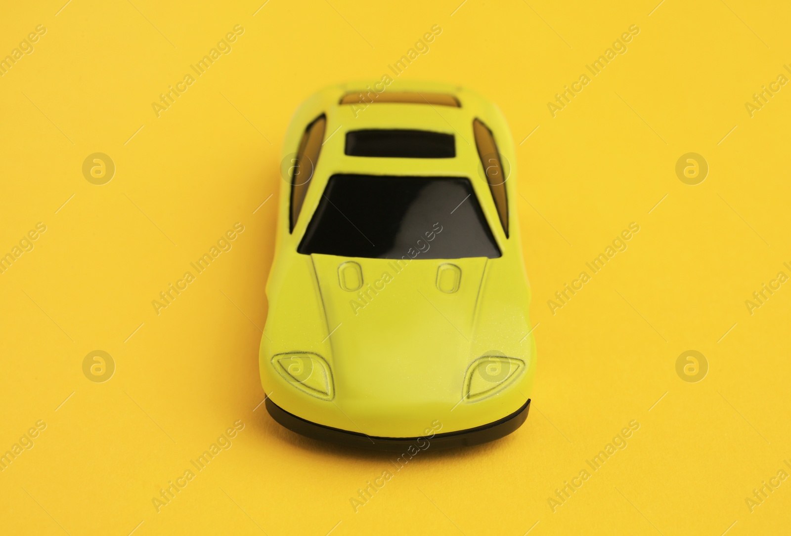 Photo of One bright car on yellow background. Children`s toy