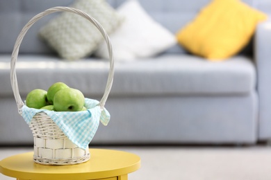 Photo of Basket with ripe green apples on table indoors