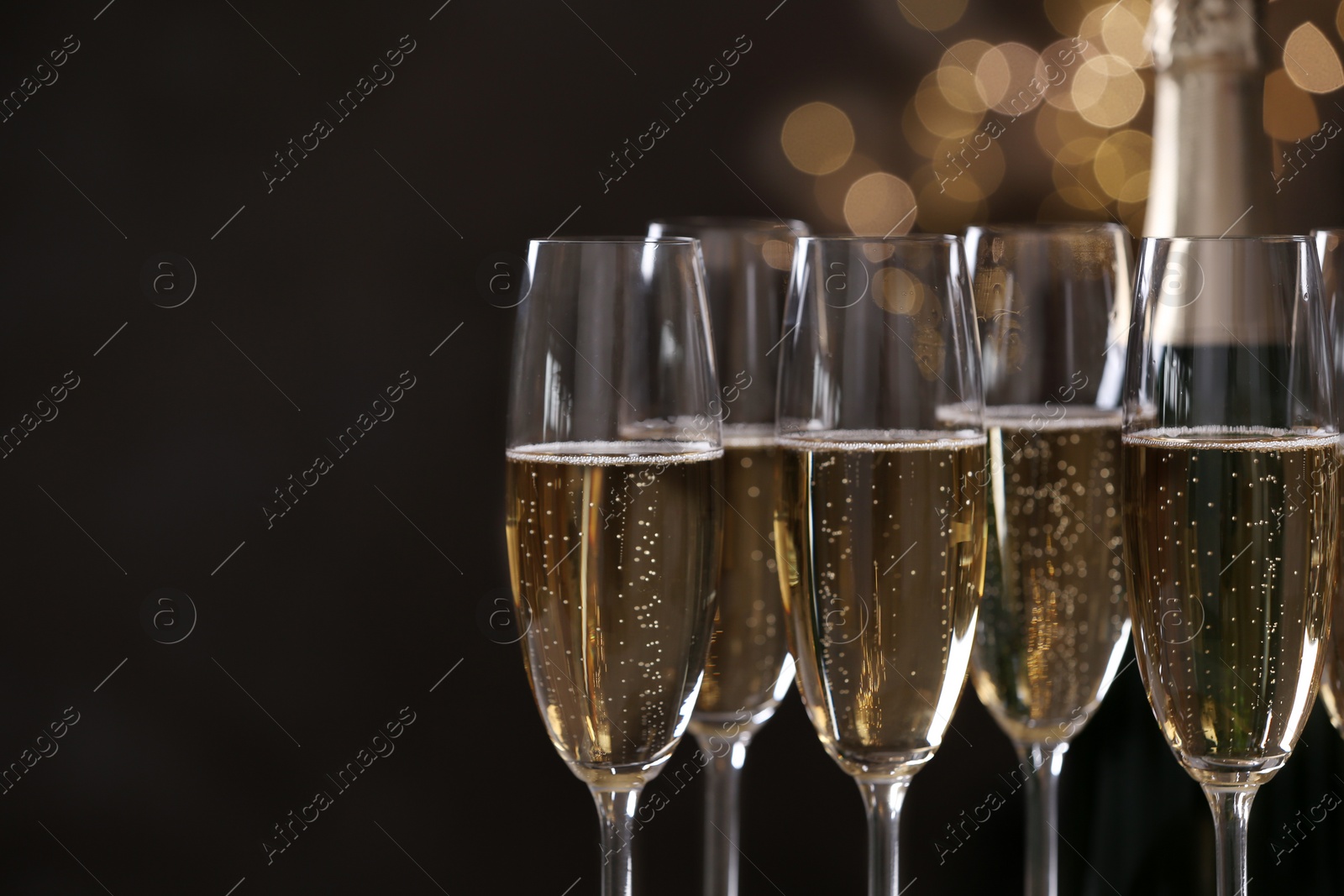 Photo of Glasses of champagne on blurred background, closeup. Space for text