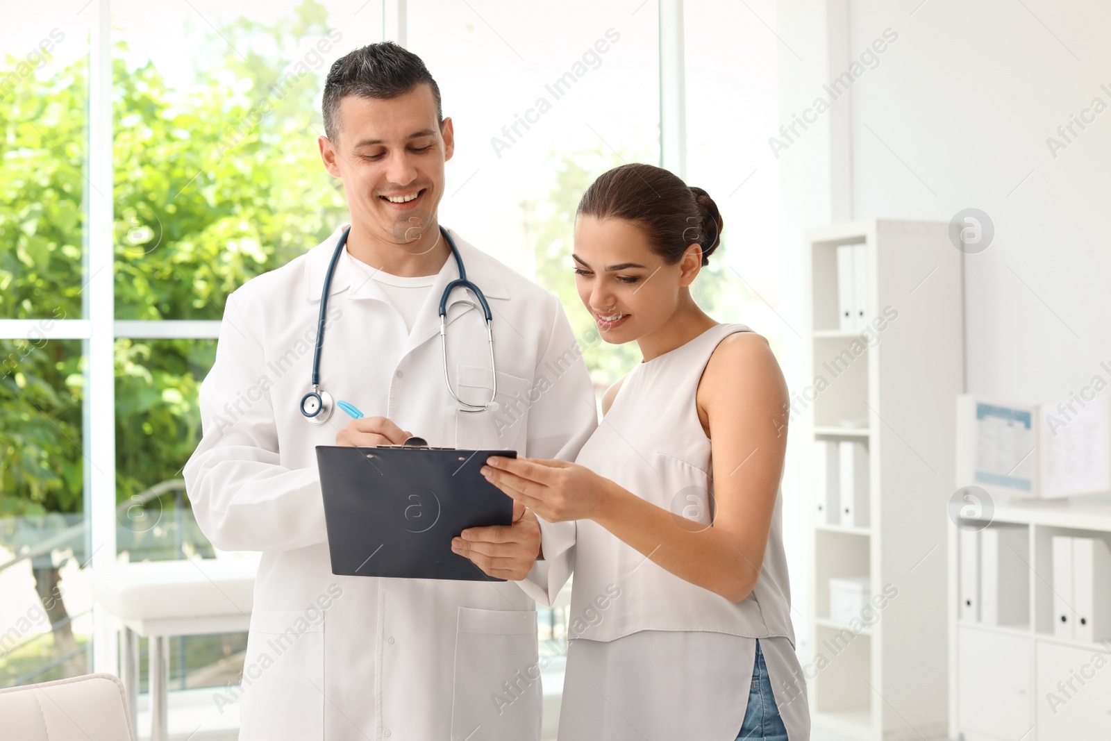 Photo of Young doctor speaking to patient in hospital