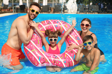 Photo of Happy family having fun in swimming pool