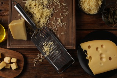 Different types of cheese and grater on wooden table, flat lay