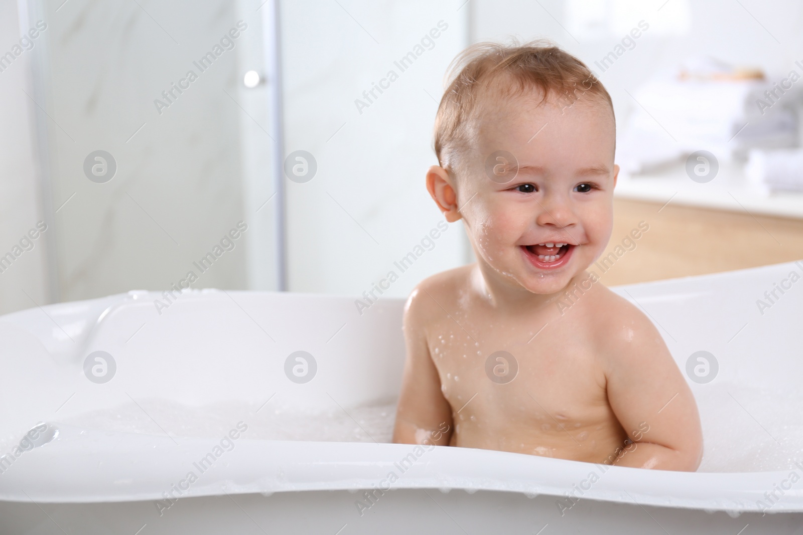 Photo of Cute little baby in bathtub at home