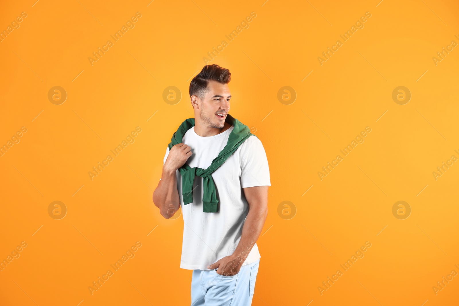 Photo of Young man in stylish jeans on color background