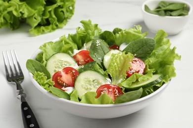 Photo of Delicious salad served on white marble table, closeup
