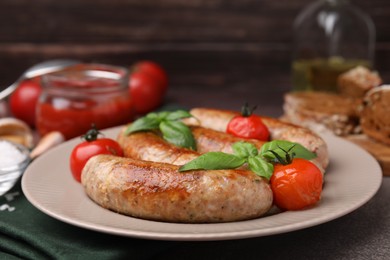 Photo of Plate with tasty homemade sausages, basil leaves and tomatoes on table, closeup