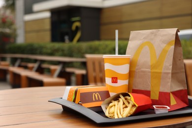 Photo of Lviv, Ukraine - October 9, 2023: McDonald's menu on wooden table outdoors, space for text