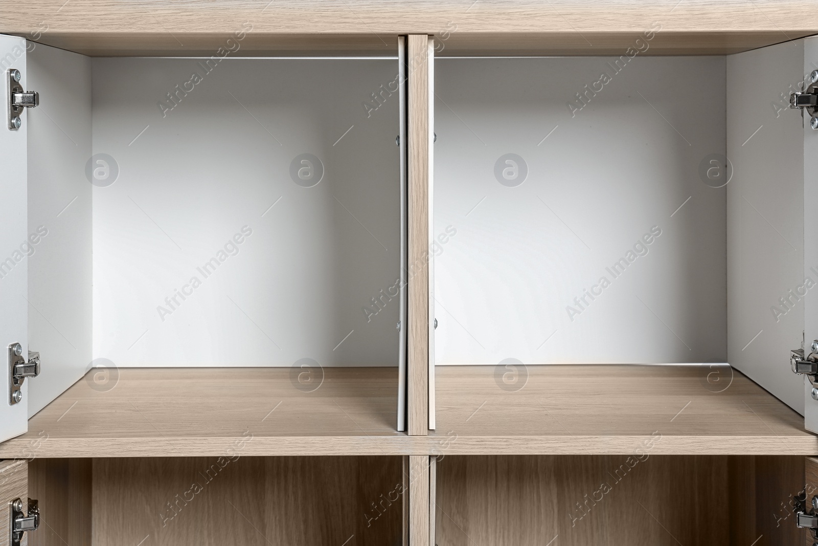 Photo of Empty wardrobe compartments, closeup view. Stylish furniture