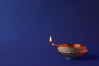 Diwali diya or clay lamp on color background