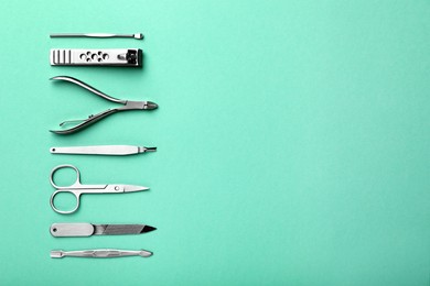 Set of manicure tools on turquoise background, flat lay. Space for text