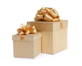 Photo of Golden gift boxes with satin bows on white background