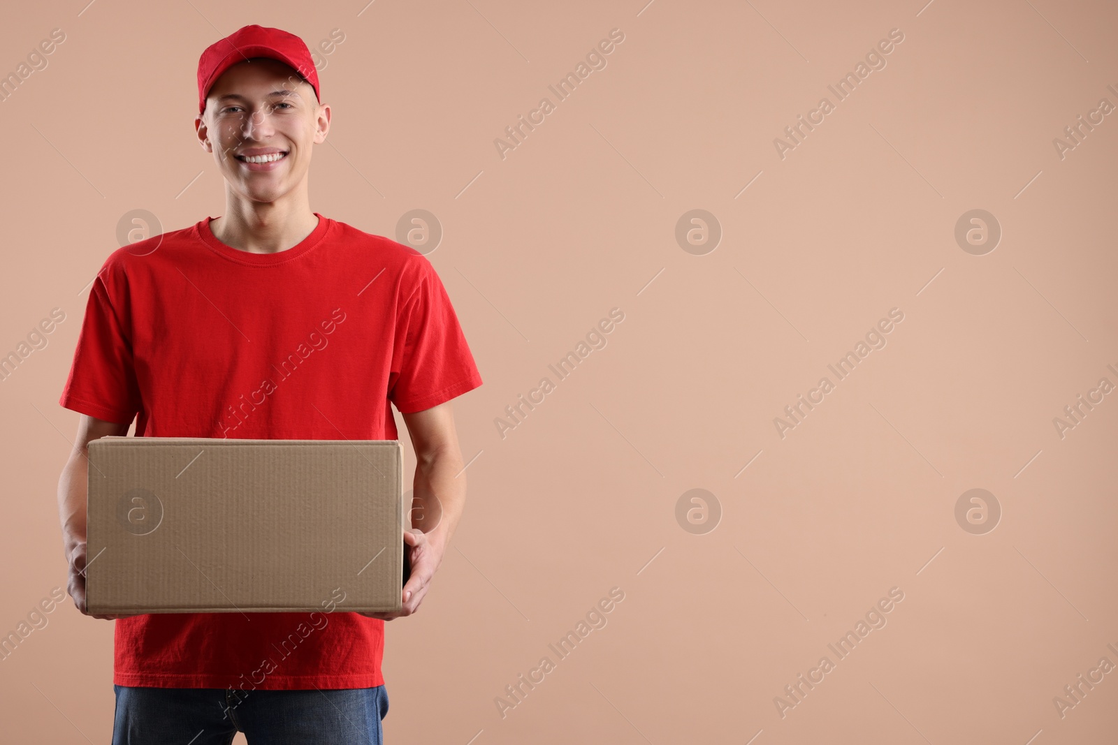 Photo of Happy courier with parcel on beige background. Space for text