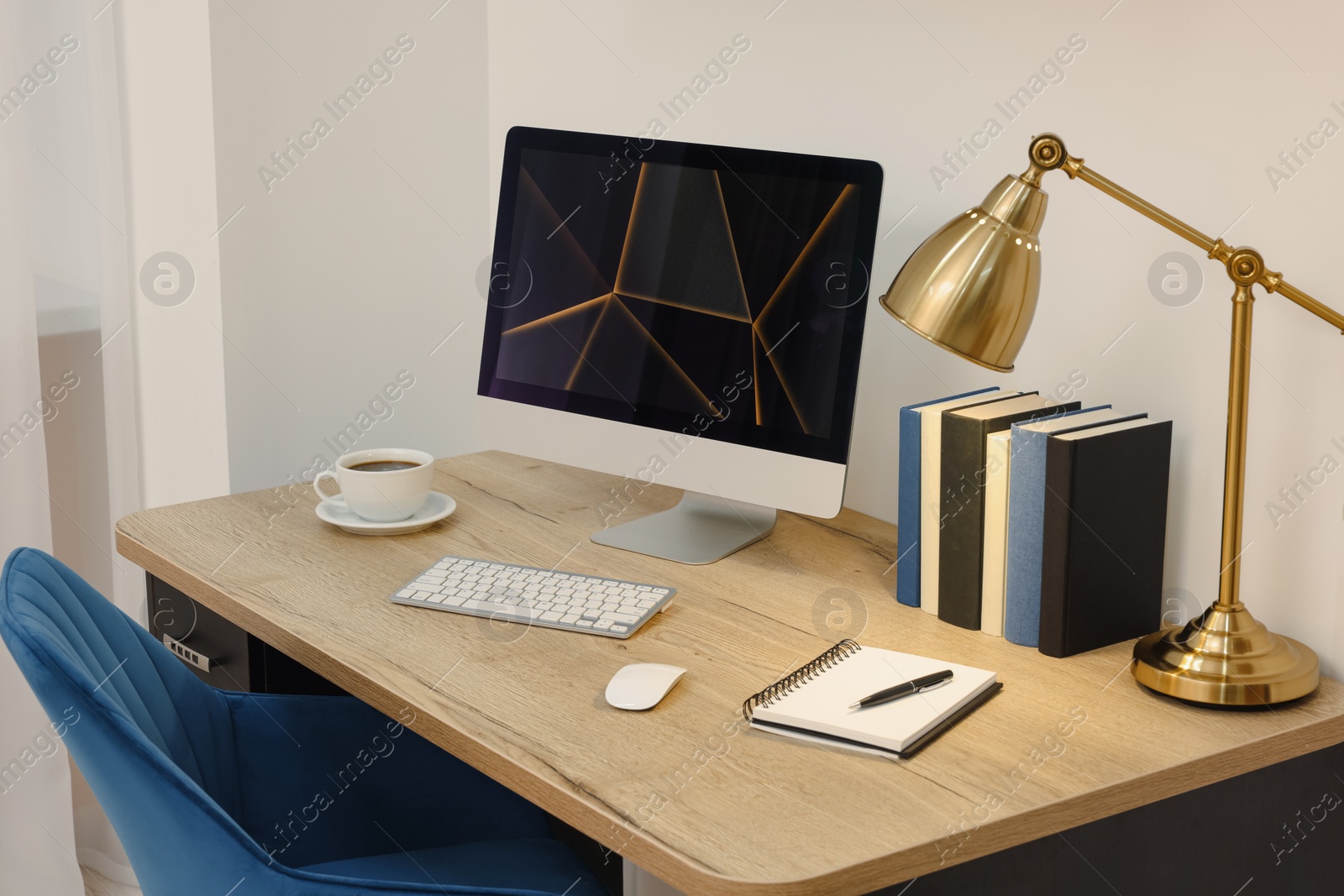 Photo of Cozy workspace with computer on wooden desk and comfortable chair at home