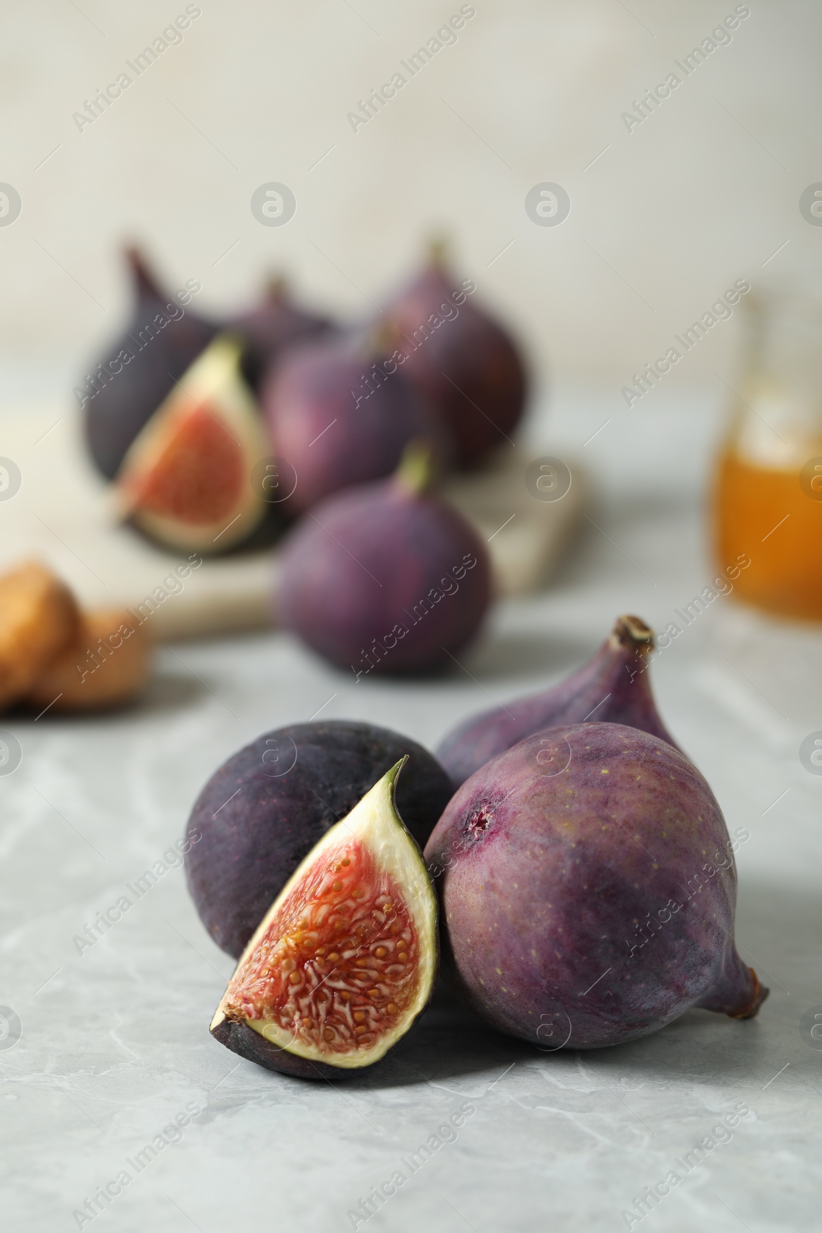 Photo of Tasty raw figs on light grey marble table. Space for text
