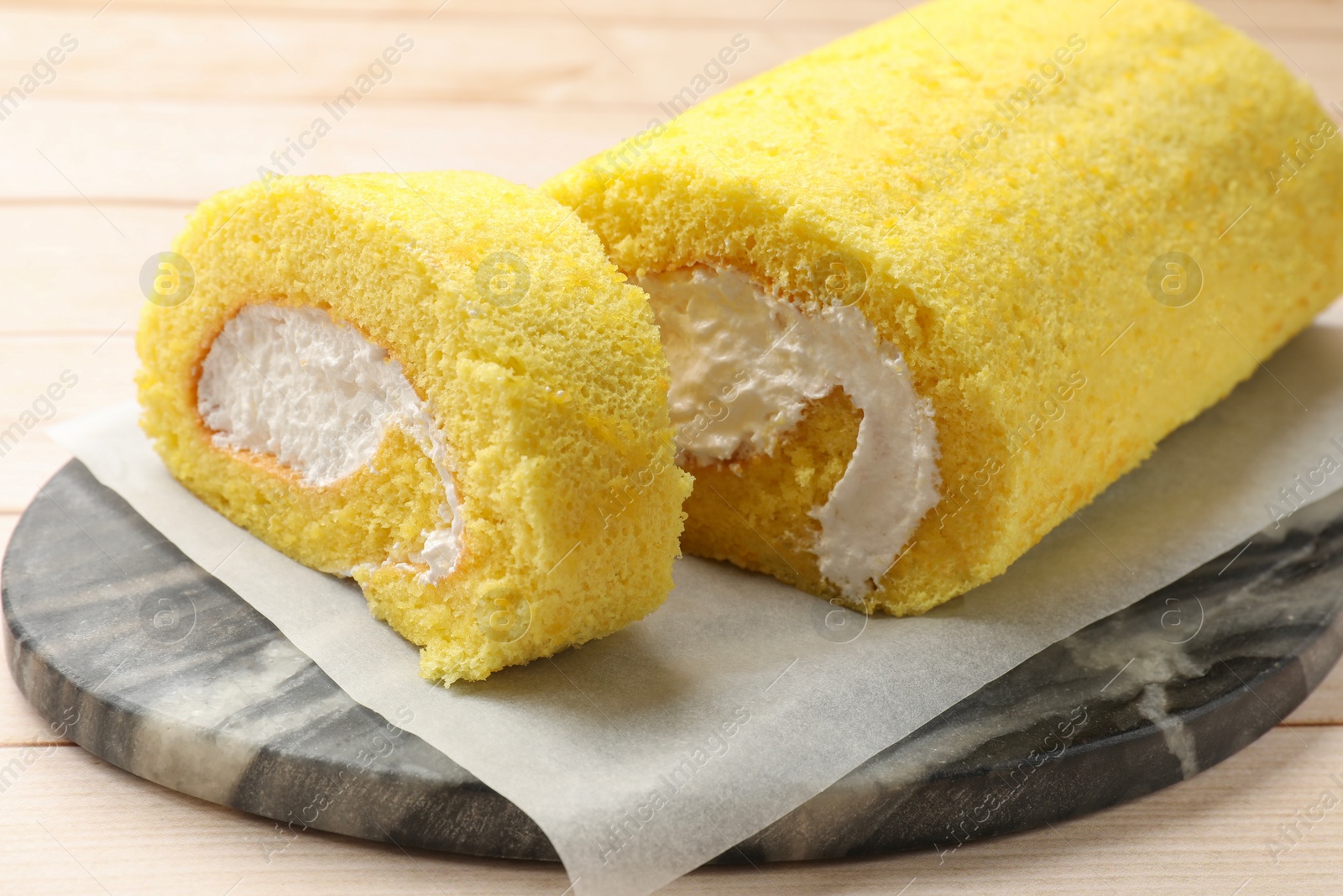 Photo of Cut delicious cake roll on table, closeup