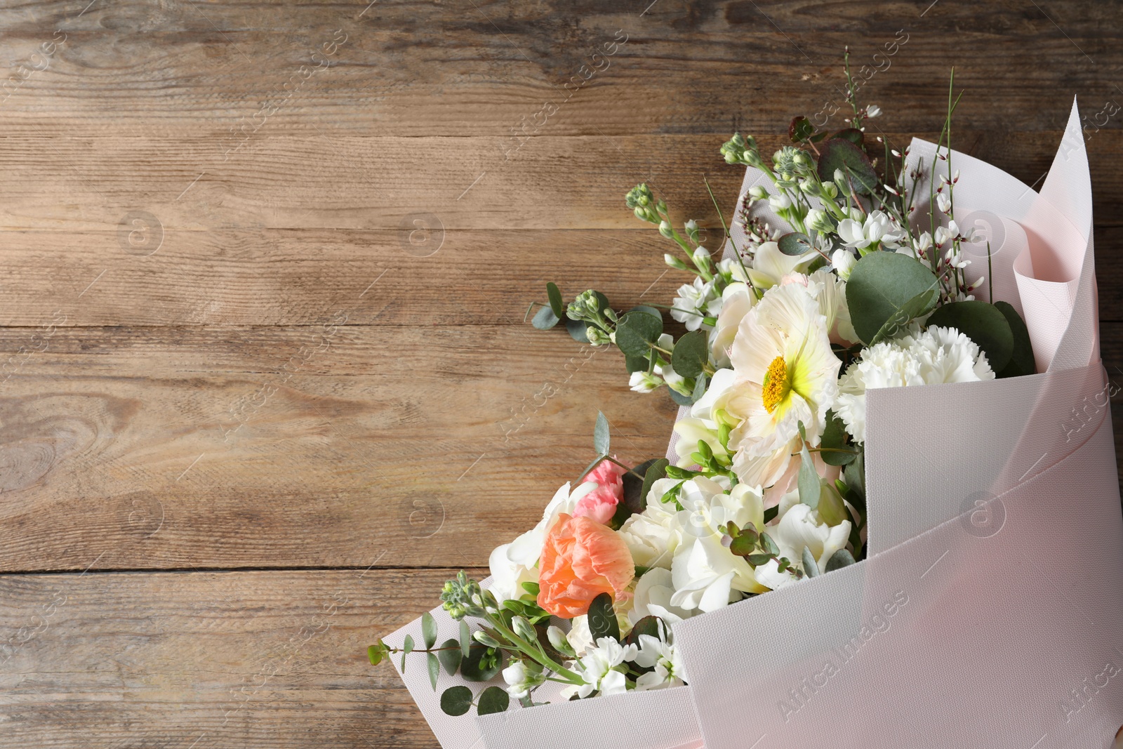 Photo of Bouquet of beautiful flowers on wooden table, top view. Space for text