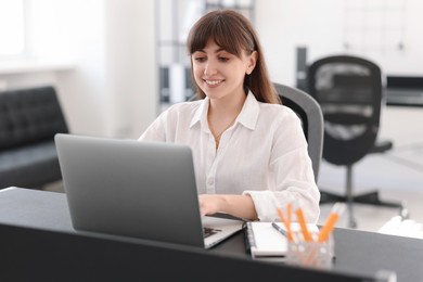 Woman watching webinar at table in office