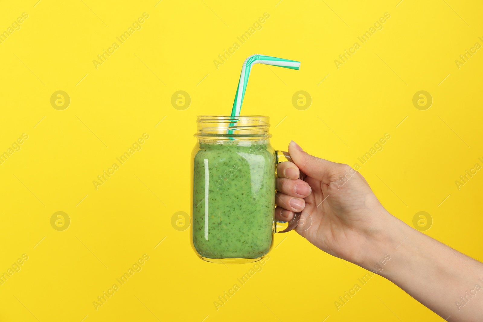 Photo of Woman holding mason jar with delicious smoothie on color background