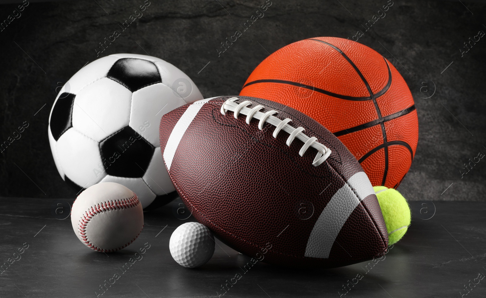 Photo of Many different sports balls on dark gray background