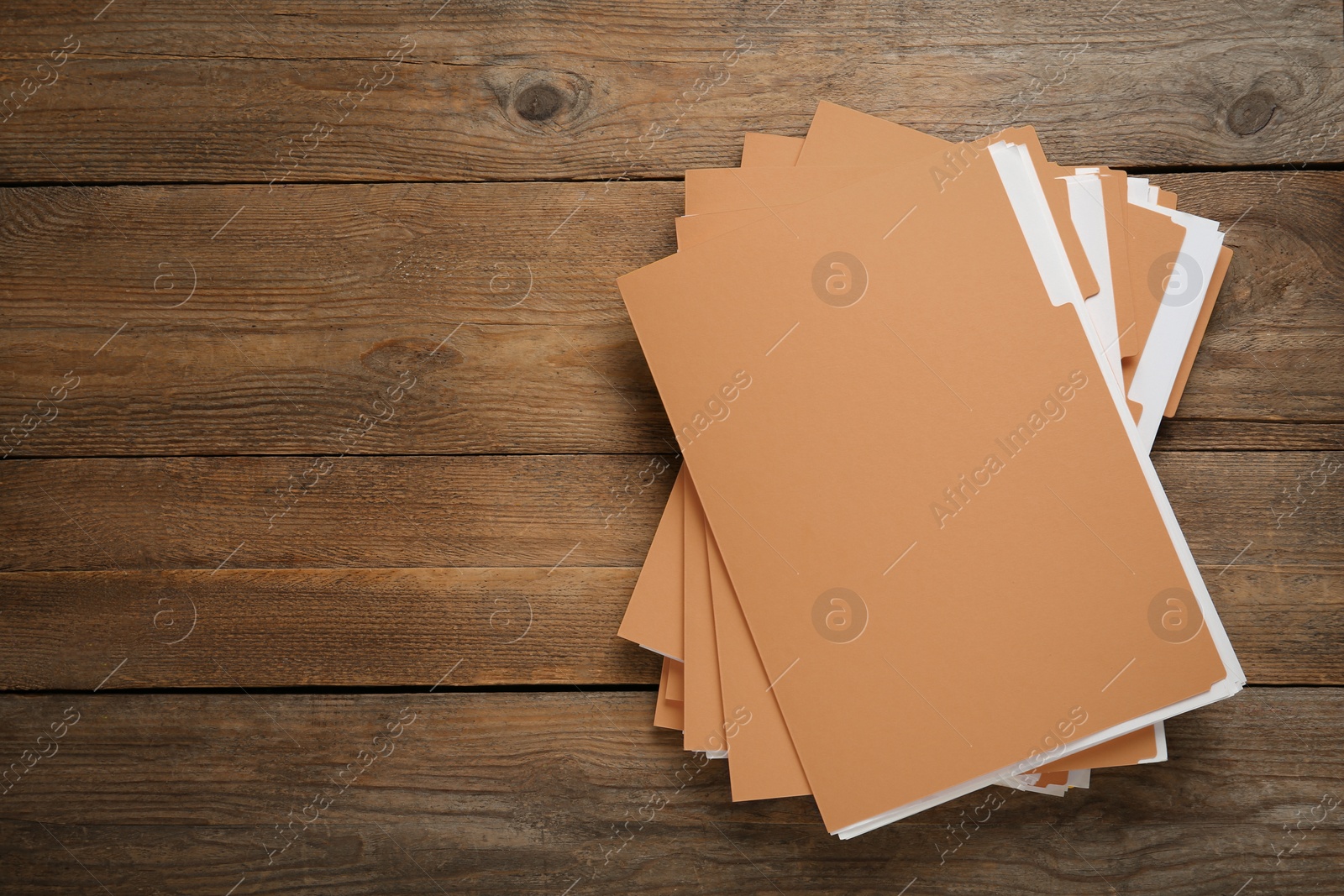 Photo of Yellow files with documents on wooden table, top view. Space for text