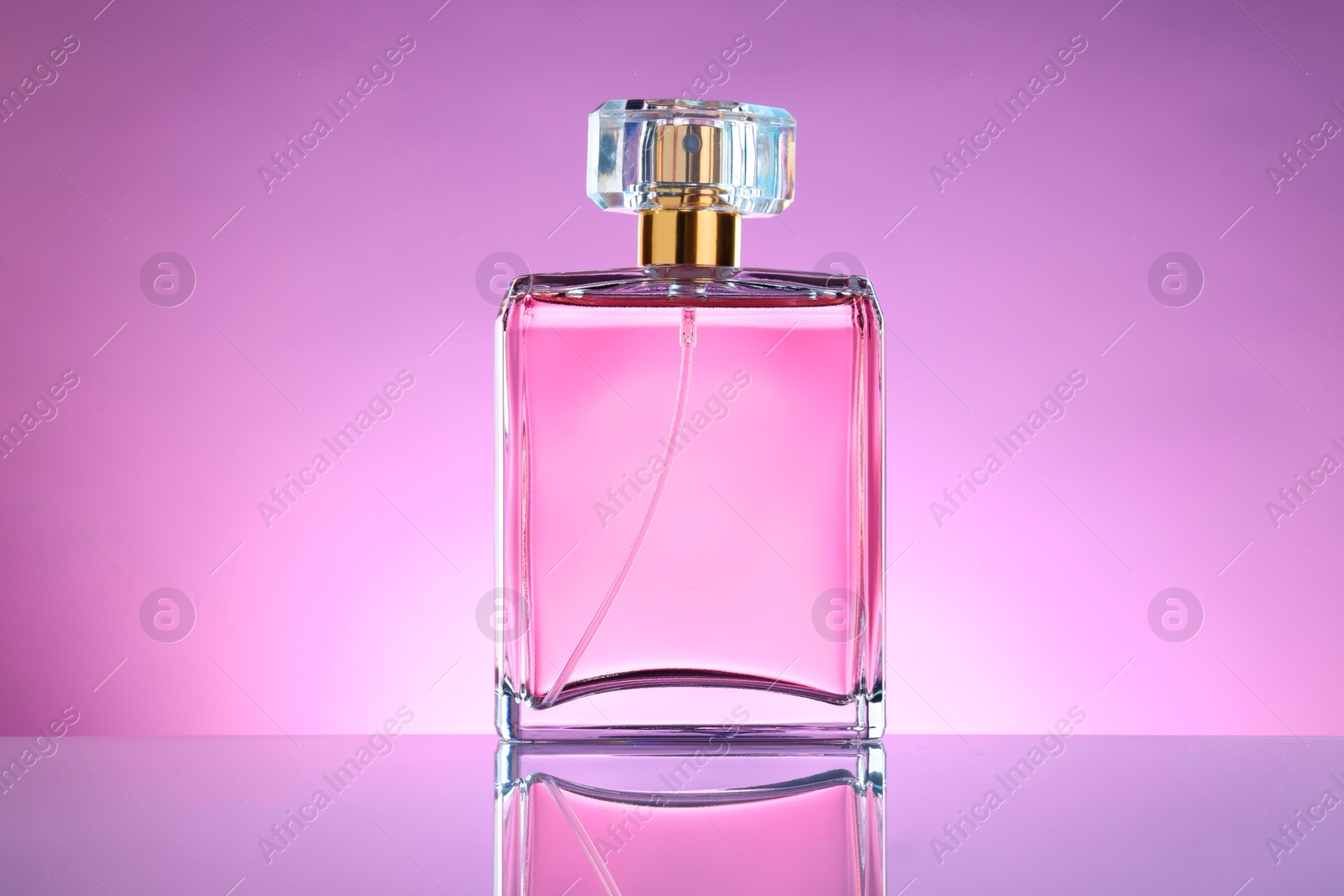 Photo of Luxury women's perfume in bottle on violet background