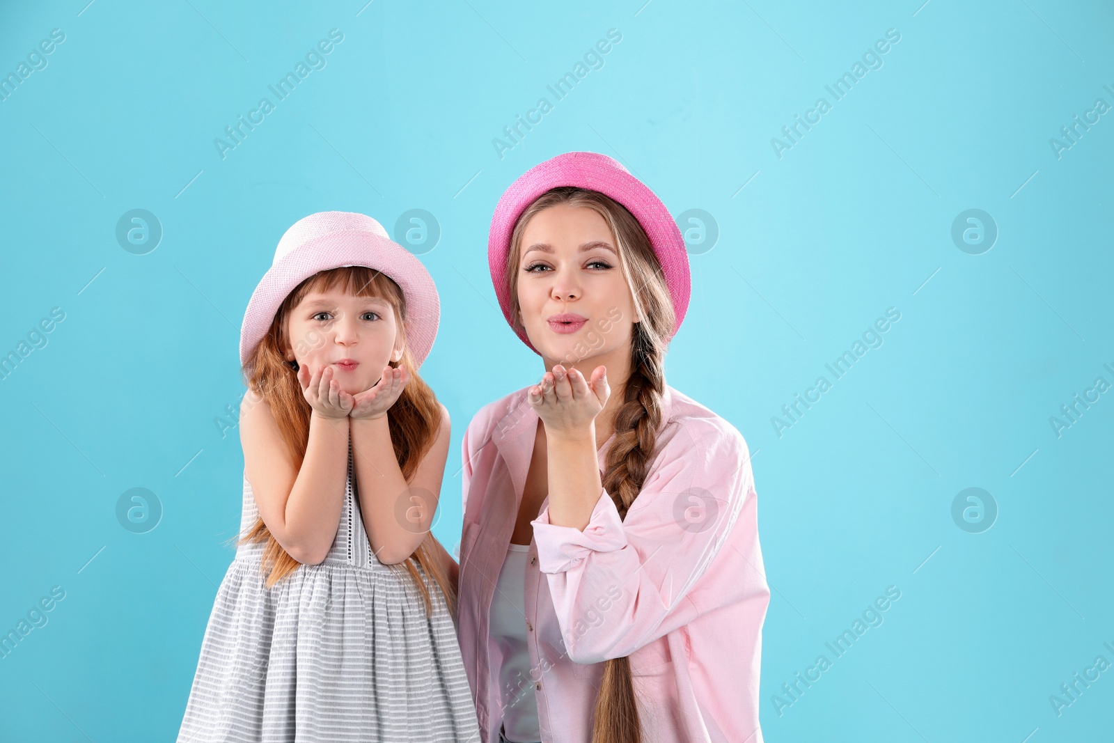 Photo of Happy woman and daughter in stylish clothes on color background