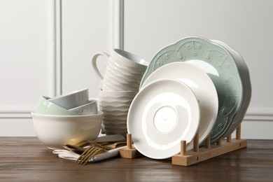 Photo of Beautiful ceramic dishware, cups and cutlery on wooden table