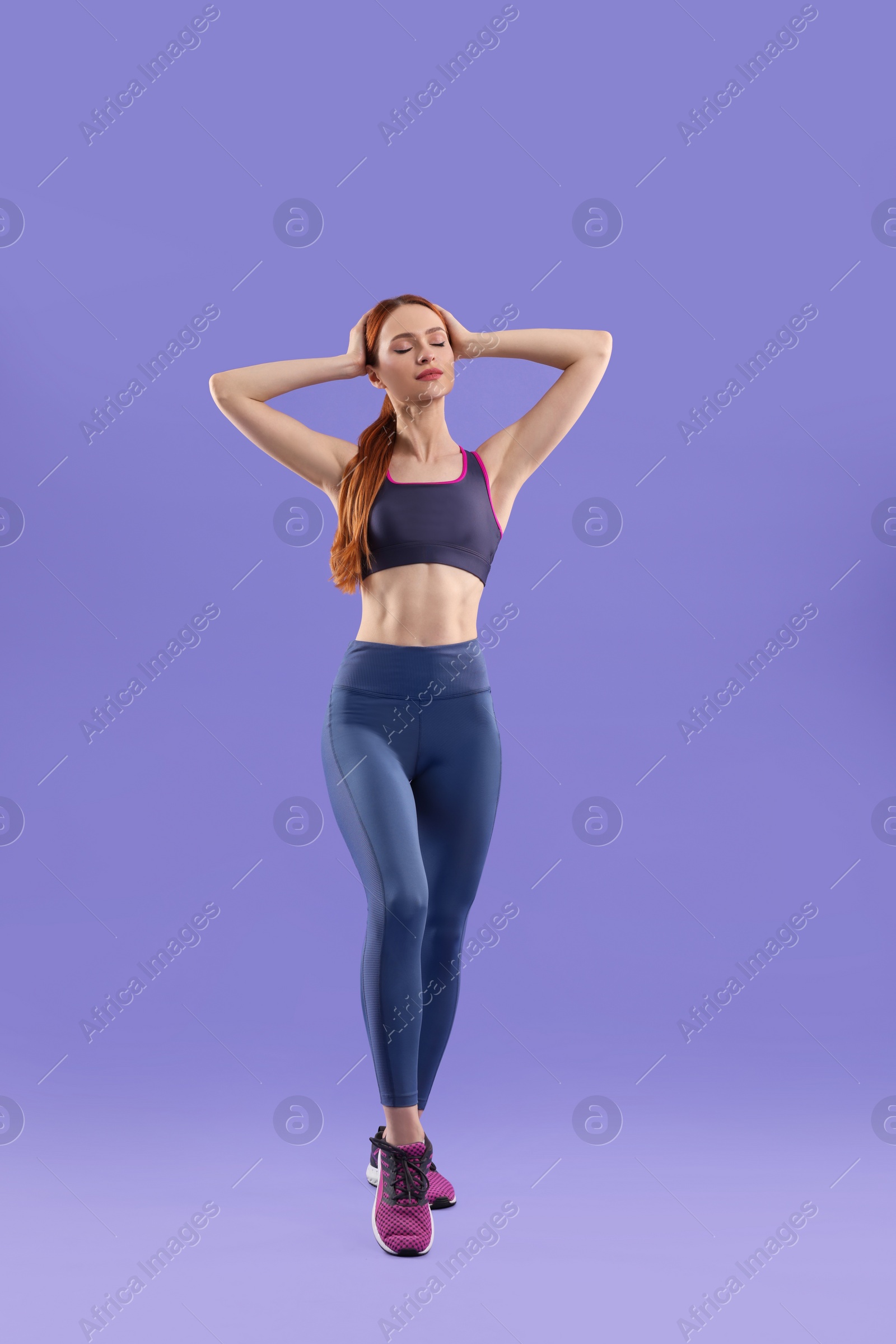 Photo of Young woman wearing sportswear on violet background