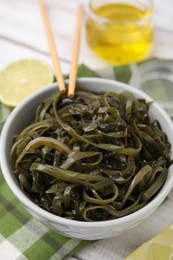 Photo of Tasty seaweed salad in bowl served on table, closeup