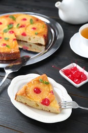 Photo of Piece of delicious pineapple pie with cherry and mint on black wooden table