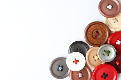 Many colorful sewing buttons on white background, top view