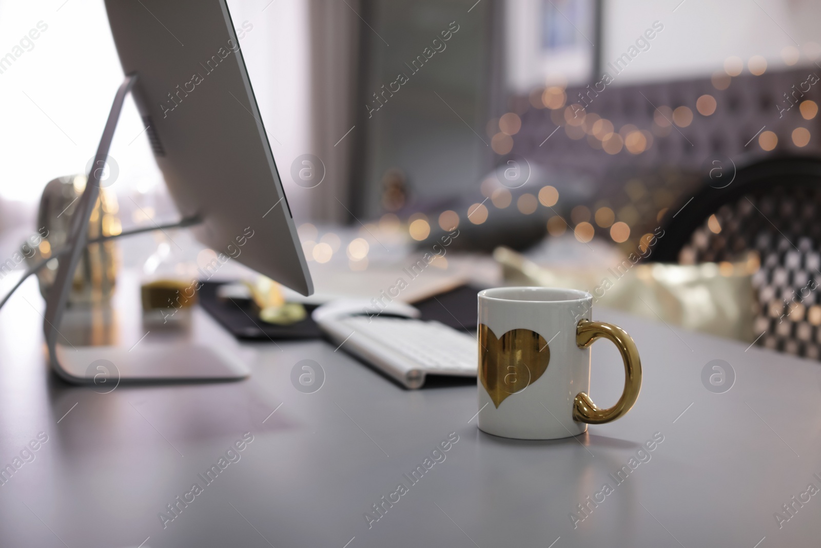 Photo of Stylish workplace with modern computer on desk. Focus on cup of drink