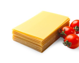 Photo of Stack of uncooked lasagna sheets and tomatoes isolated on white