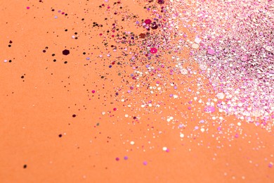 Photo of Shiny bright pink glitter on coral background