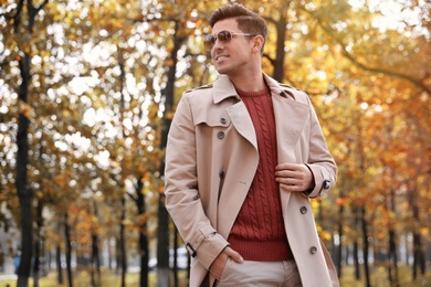 Photo of Handsome man walking in park on autumn day