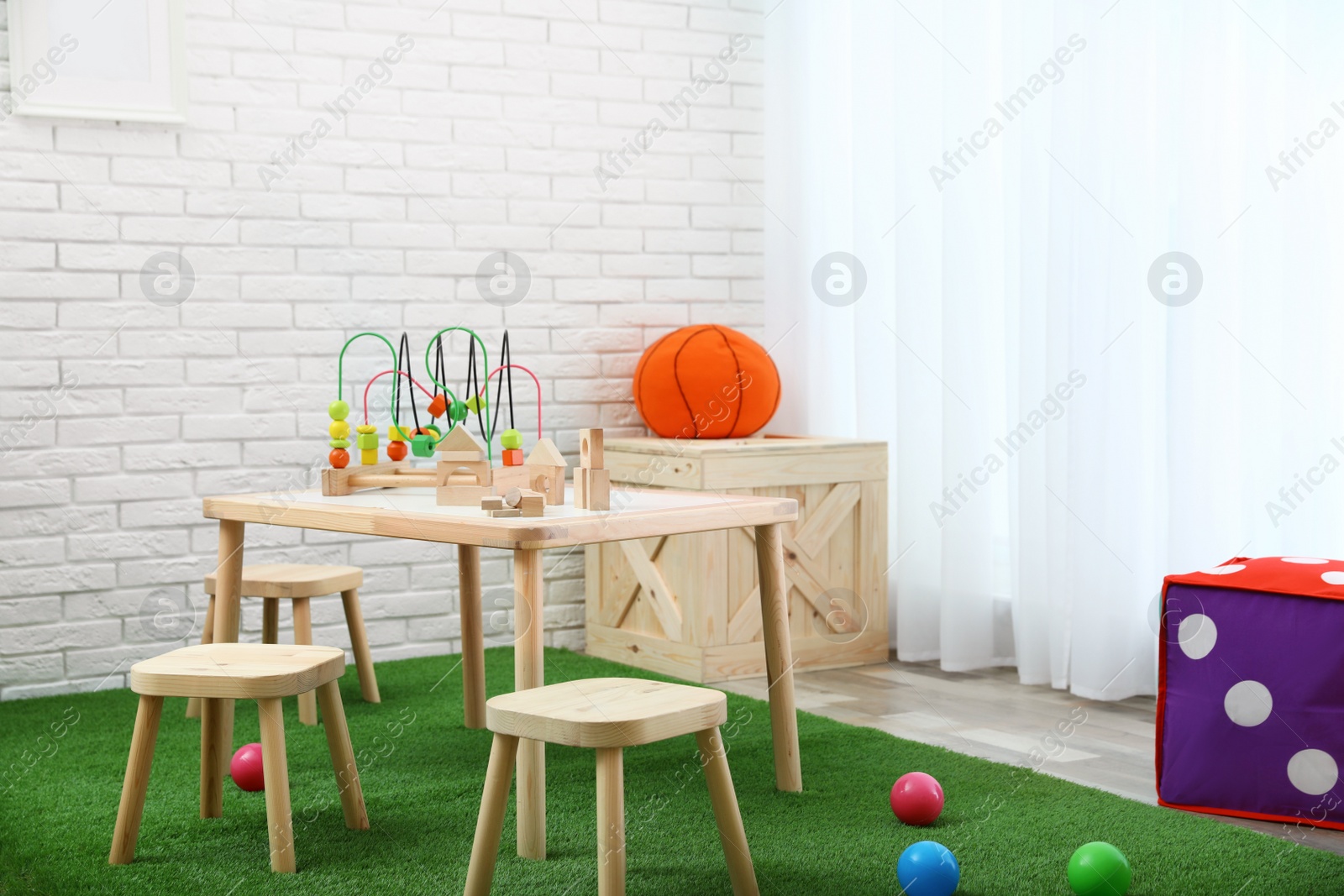 Photo of Stylish playroom interior with toys and modern wooden furniture