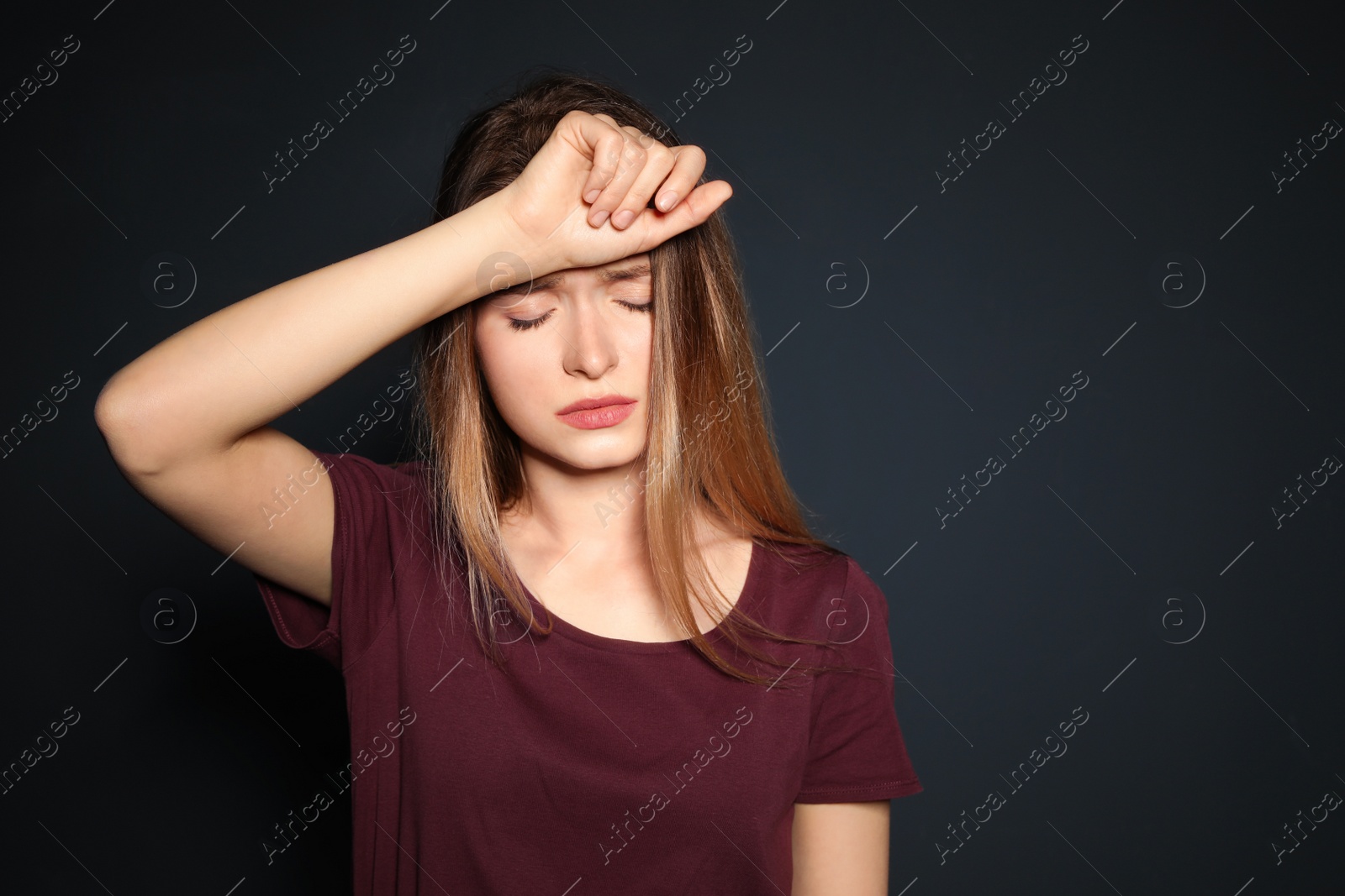 Photo of Portrait of upset young woman on dark background. Space for text