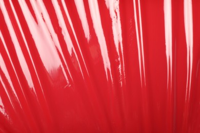 Red plastic stretch wrap as background, top view