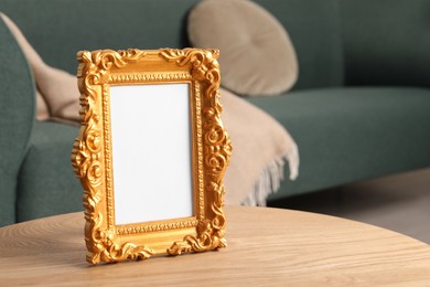 Beautiful vintage empty frame on wooden table indoors, space for text